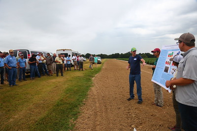 Photo shows presenters at the 2019 Pine Tree Field Day holding a poster, speaking to attendees.