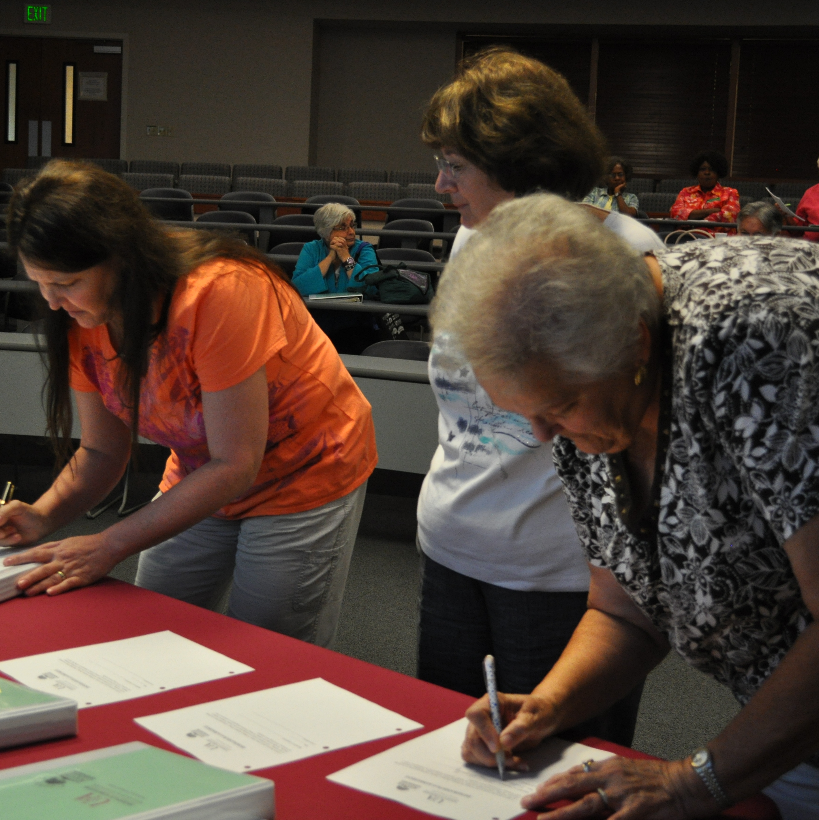 Photo of three Master Gardeners signing a list at a table