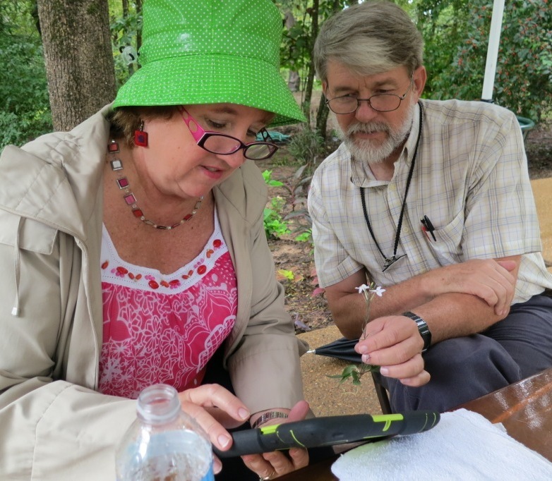 Photo of Janet Carson and Bob Byers identifying a flower from Garvan Woodland Gardens in Hot Springs, AR. 