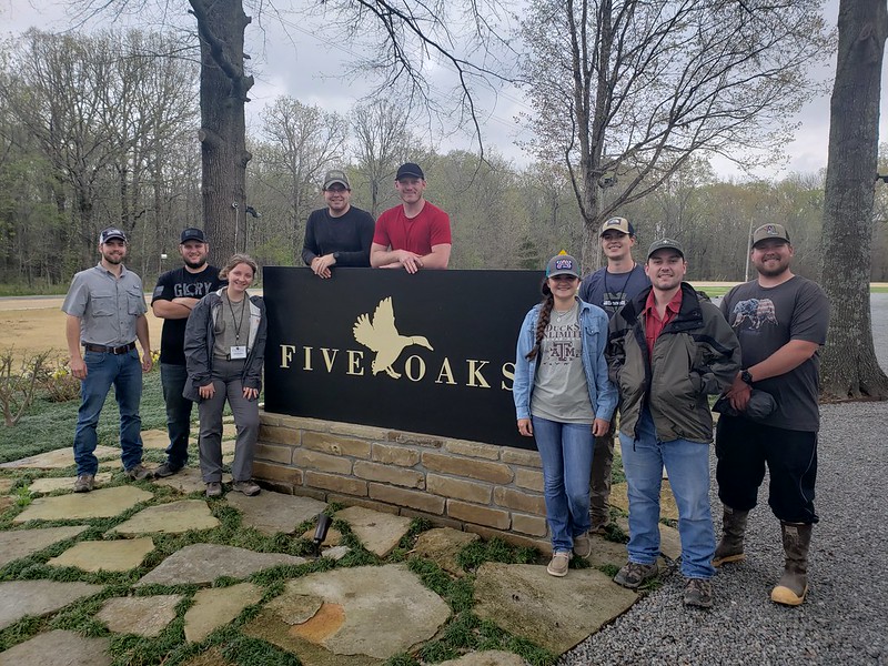Group standing with Five Oaks sign