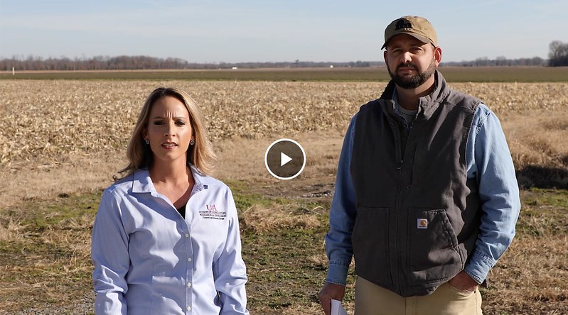 County agent and producer standing in a field.