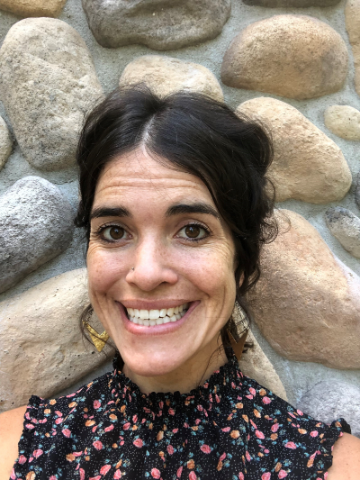 Photo of Lindsay Kuehn, smiling, wearing a floral blouse.