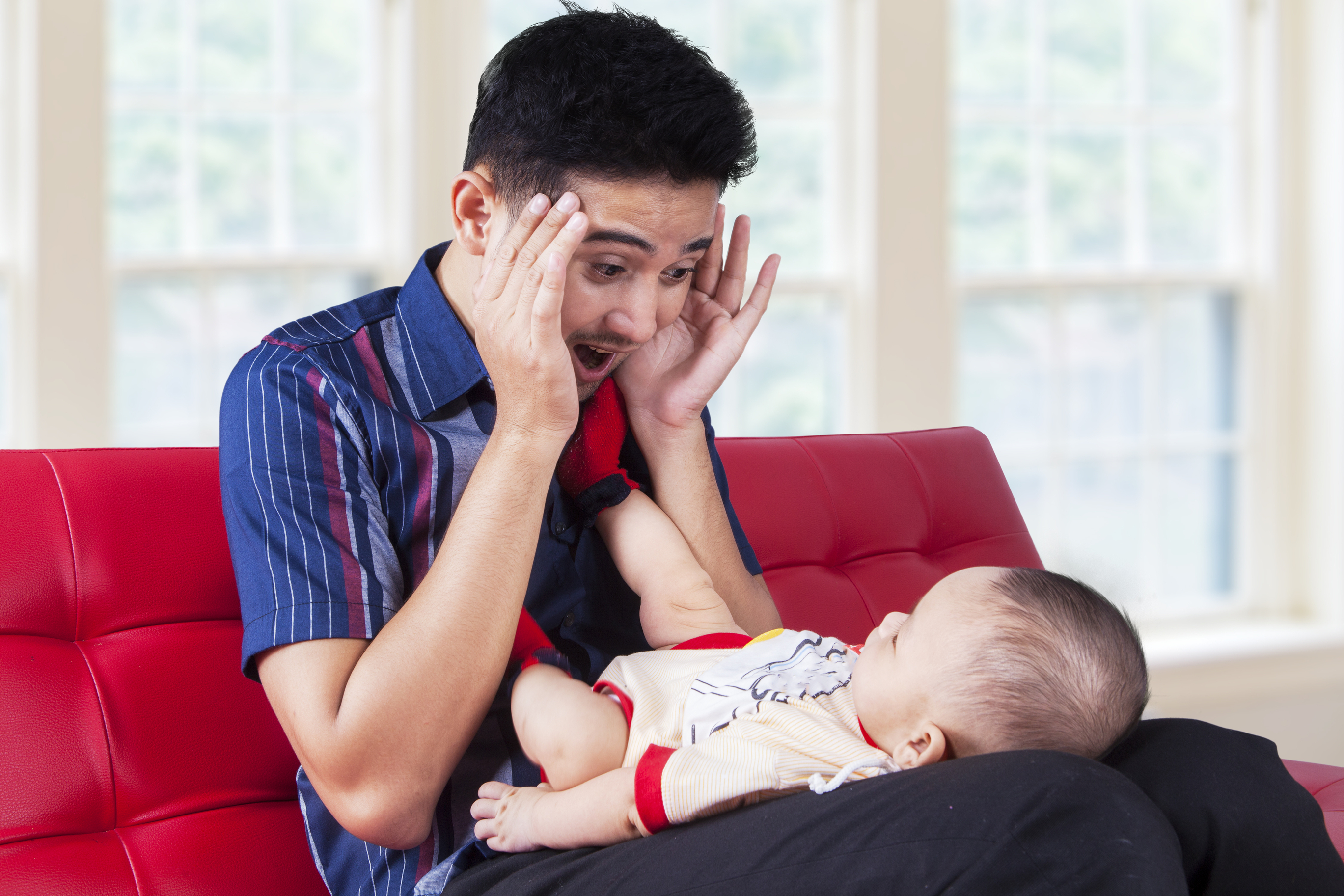 Dad plays peek-a-boo with baby