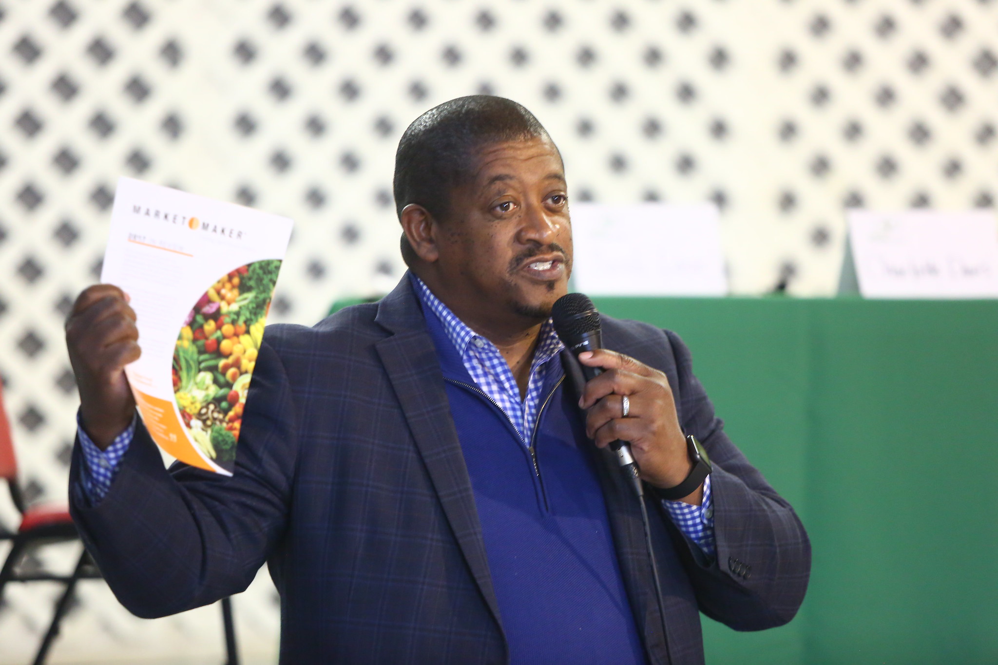 Ron Rainey 2020 Man holding up a brochure while speaking to a group.