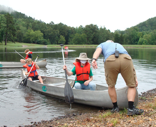 Masked campers getting canoe going. Masked campers getting canoe going.