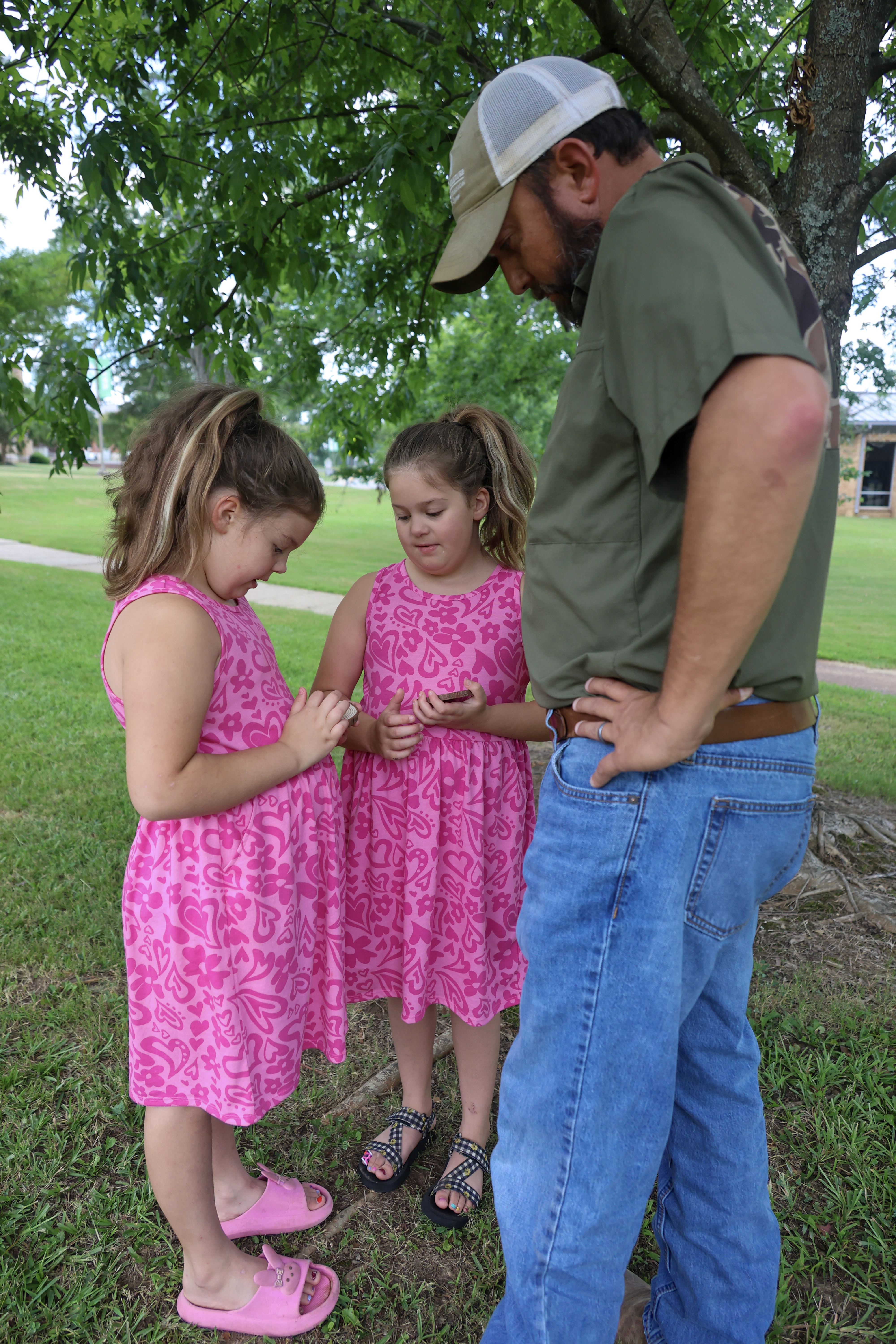 Man showing two girls a "tree cookie"