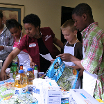 4H instructor works with kids in a cooking class and food is on the table