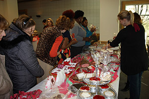 people gathered around dessert table with valentines decorations