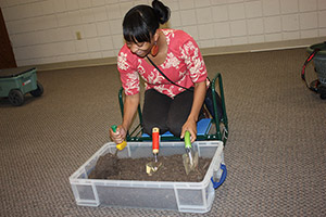 woman trying out ergonomic gardening tools in a sample flower bed