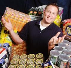 Smiling Man standing surrounded by boxes of food
