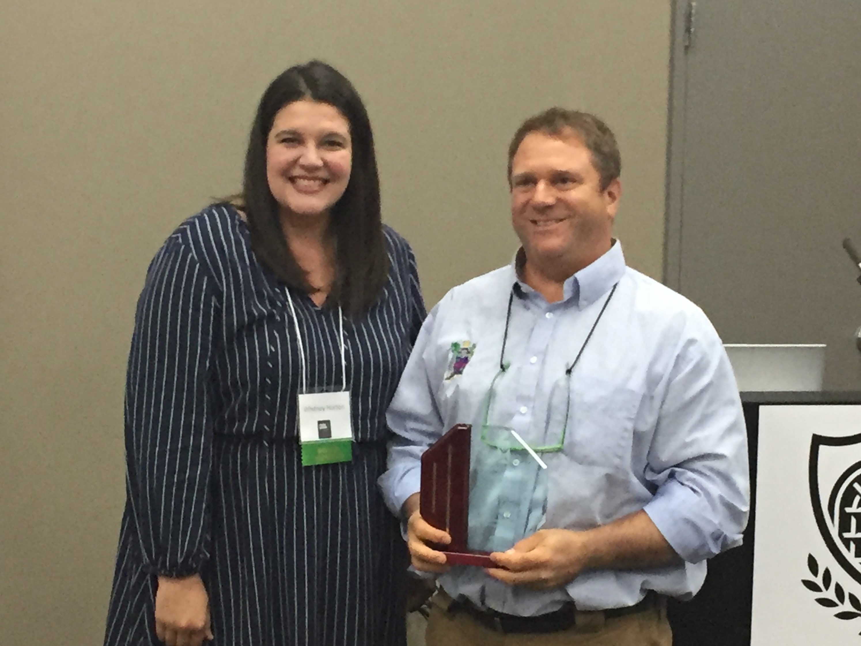 Ed Levy is presented with an award from Whitney Horton, Vice President of the Arkansas Community Development Society.