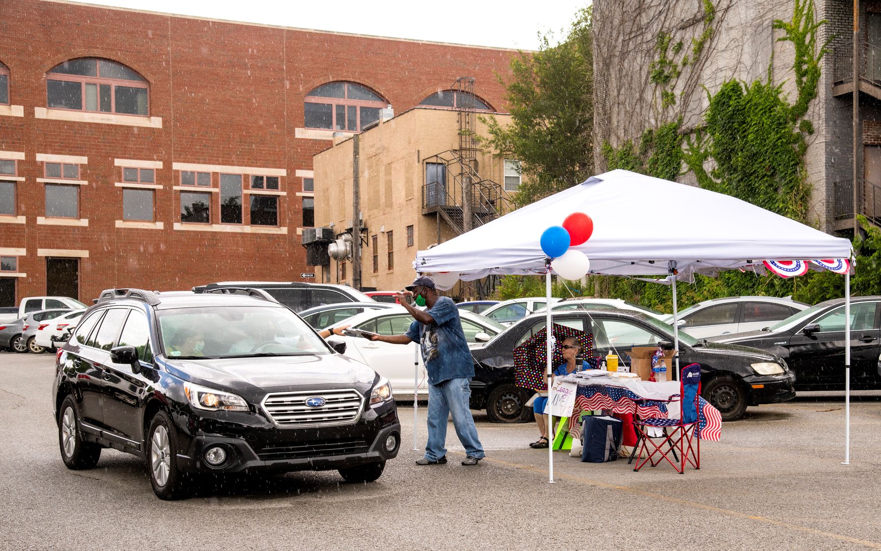 A car pulls up to a "drive & sign" event hosted by Arkansas Voters First on June 26 in Fayetteville. Photo by Fred Miller, University of Arkansas System Division of Agriculture