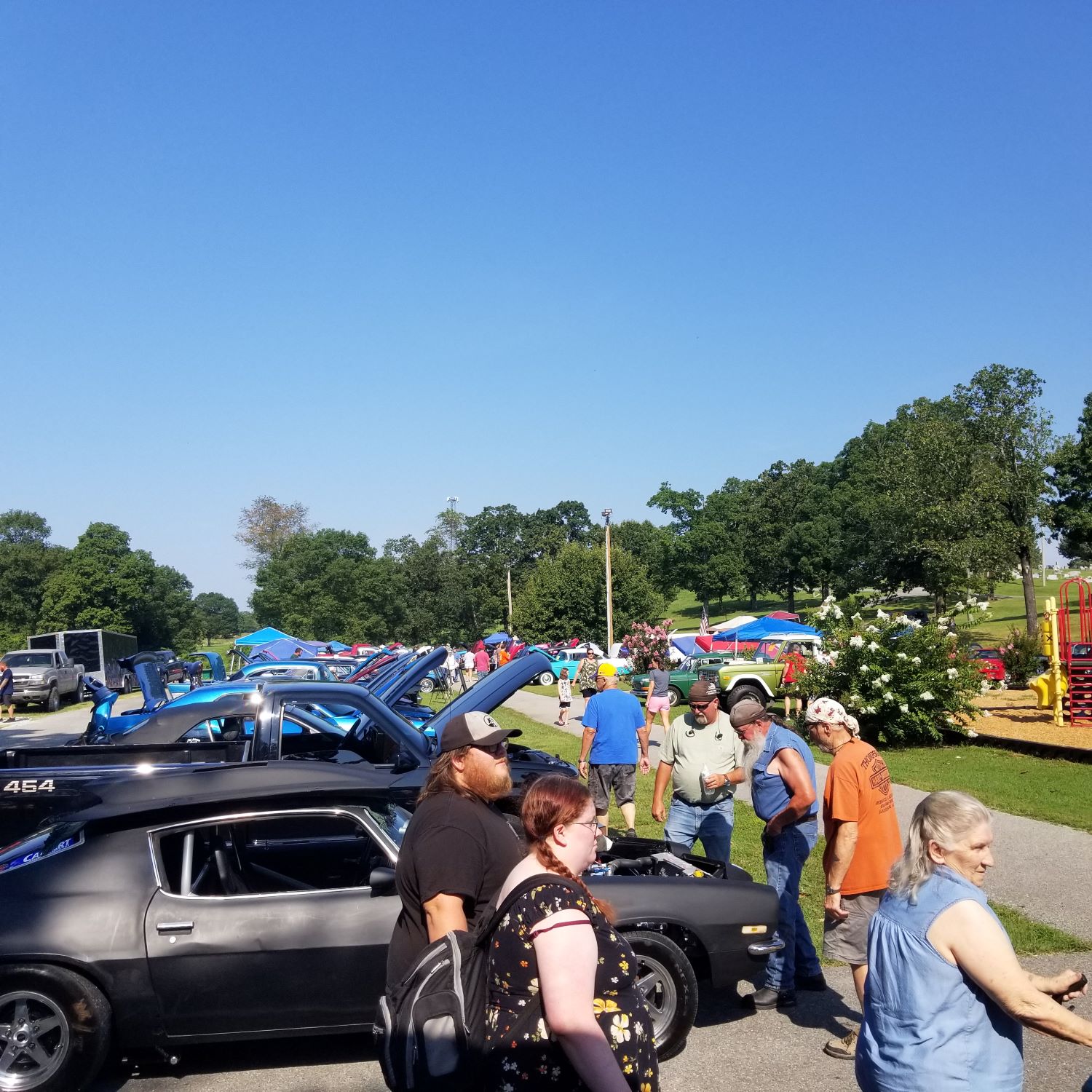 people walking around displayed cars outside