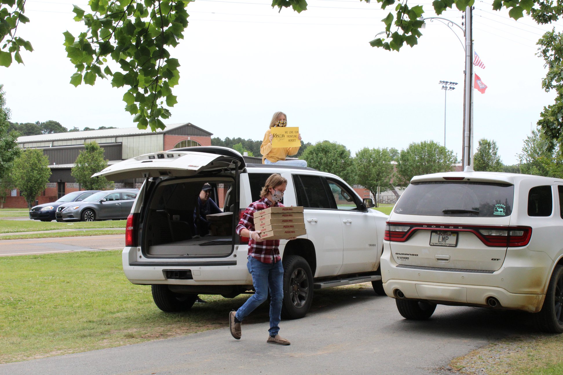 person carrying boxes from car