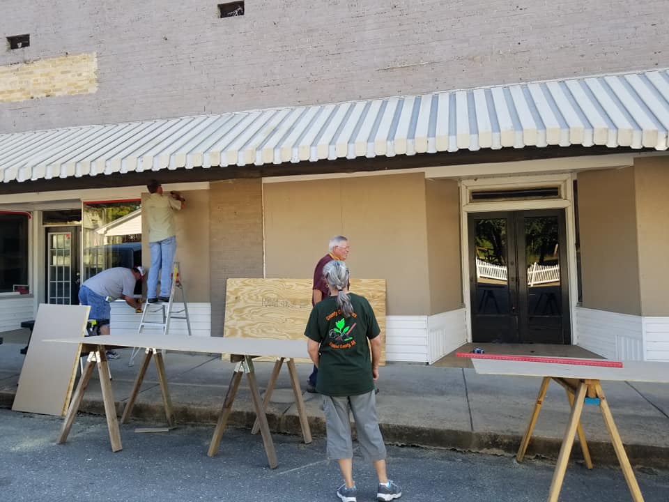 (Photo: Boarding up broken windows on Main Street, credit to Clevelend County Herald)