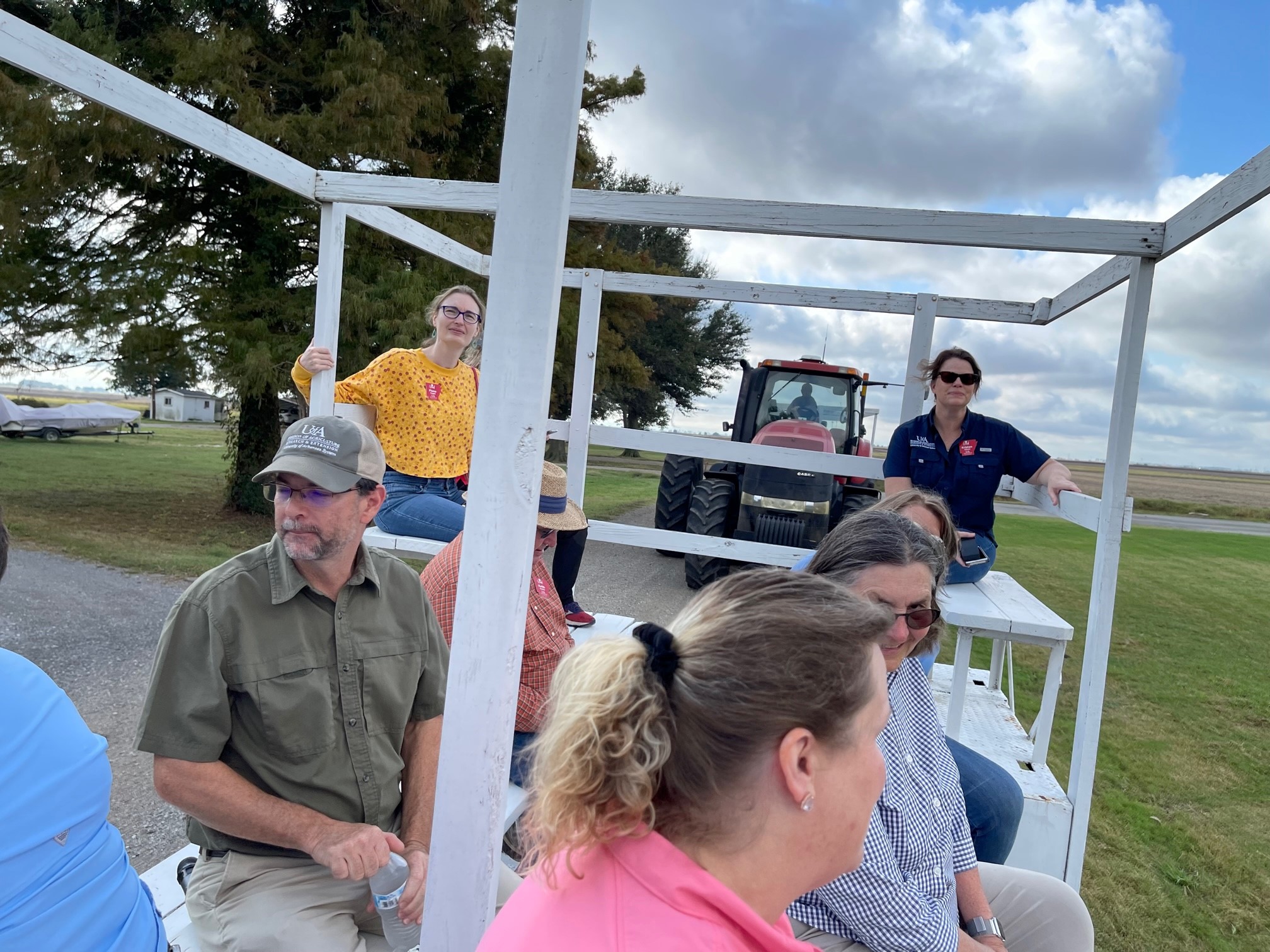 Members of the iLead class sit on an open trailer designed to take people on tours of farm fields. They toured the Northeast Research and Extension Center.