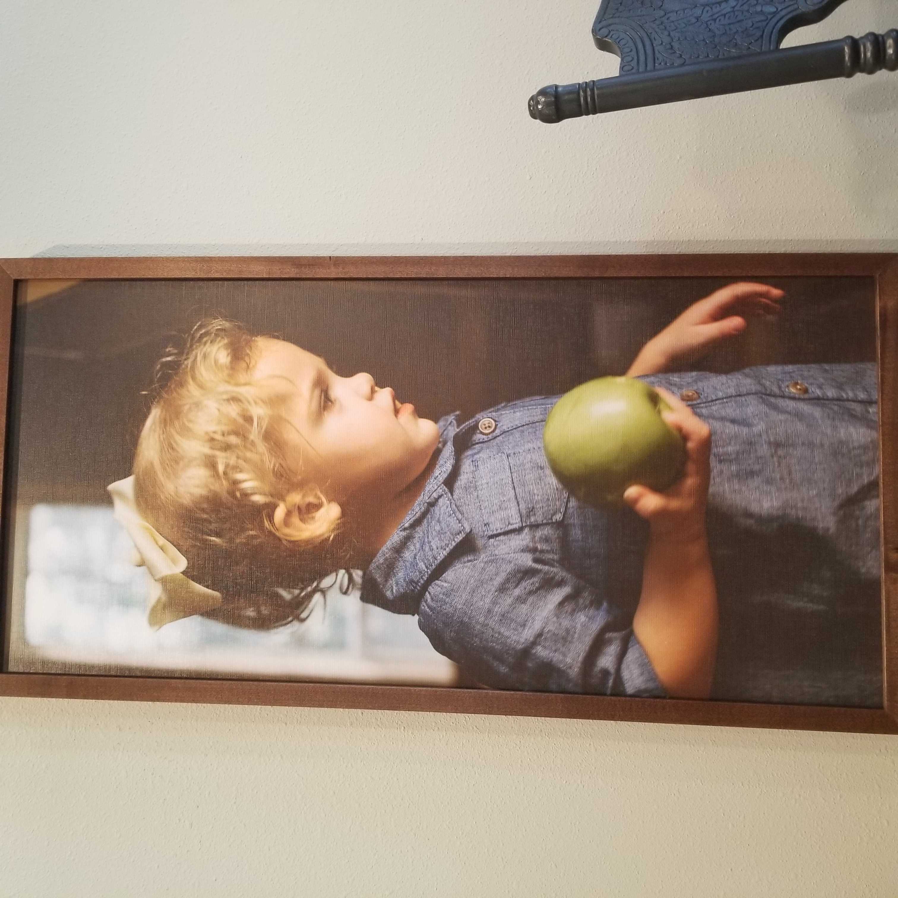 Painting of a child holding a yellow apple 