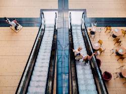 two ladies on an esculator in a mall