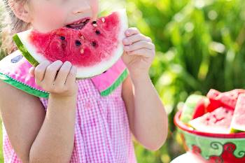 Little girl enjoying a slice of watermelon
