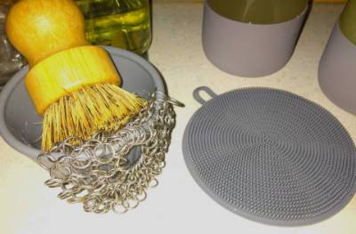 metal scrubber and rubber cleaning mat on a table