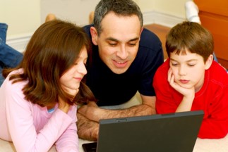 Father on his laptop showing two children, a boy and a girl
