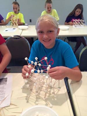 Youth participating in marshmallow building at clover college