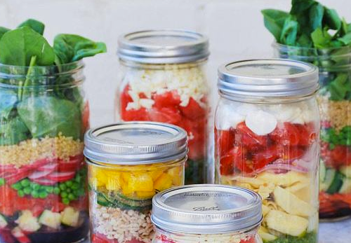 image of jars filled with layers of veggies and salad dressing