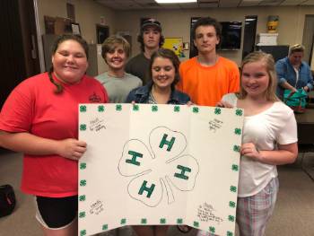 Lonoke County 4-H youth with poster