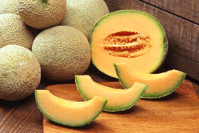 Cantaloupes, mostly whole with one sliced in half and then into wedges
