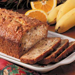 loaf of quick aloha bread sliced with bananas to the side