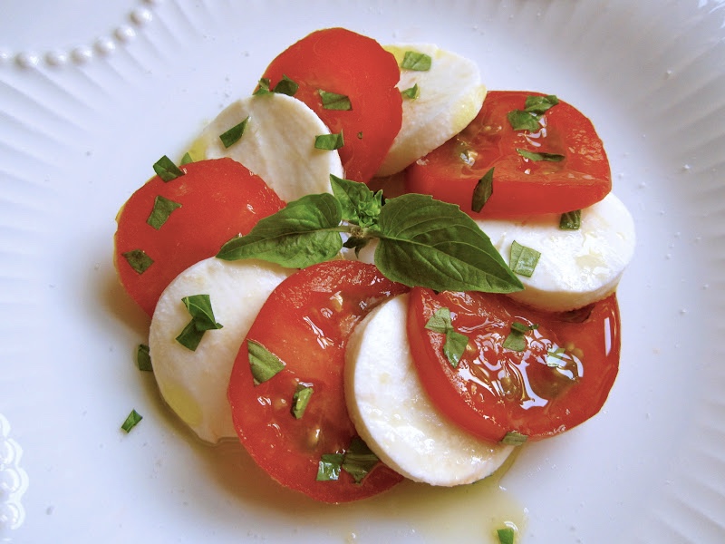 sliced tomatoes, sliced mozzarella cheese, fresh basil leaves and olive oil