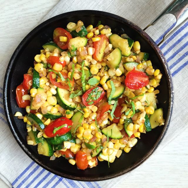 skillet loaded with fresh vegetables and herbs to make Farmers' Market Vegetable Medley