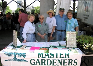 Photo of Pulaski County Master Gardeners answering questions at a Master Gardener booth at the Little Rock River Market.