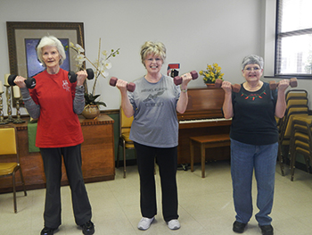 Three Pulaski County Strong Women participants practiceing weightlifting