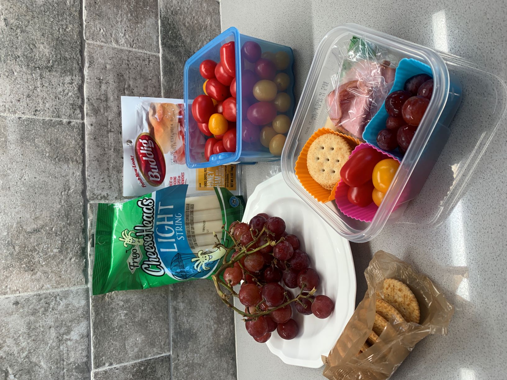 example of a homemade lunchable - grapes, tomatoes, cheese stick, ham slices, crackers