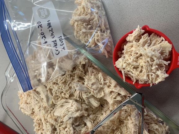 cooked shredded chicken, measuring cup, freezer bag