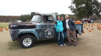 3 family members standing around truck