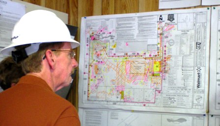 man looking at a schematic of a construction site