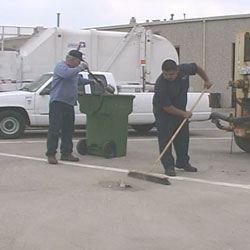 Worker cleaning dry spill with broom