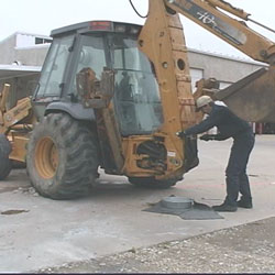 employee cleaning up leak from construction equipment