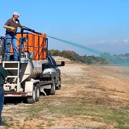 man spraying seeds