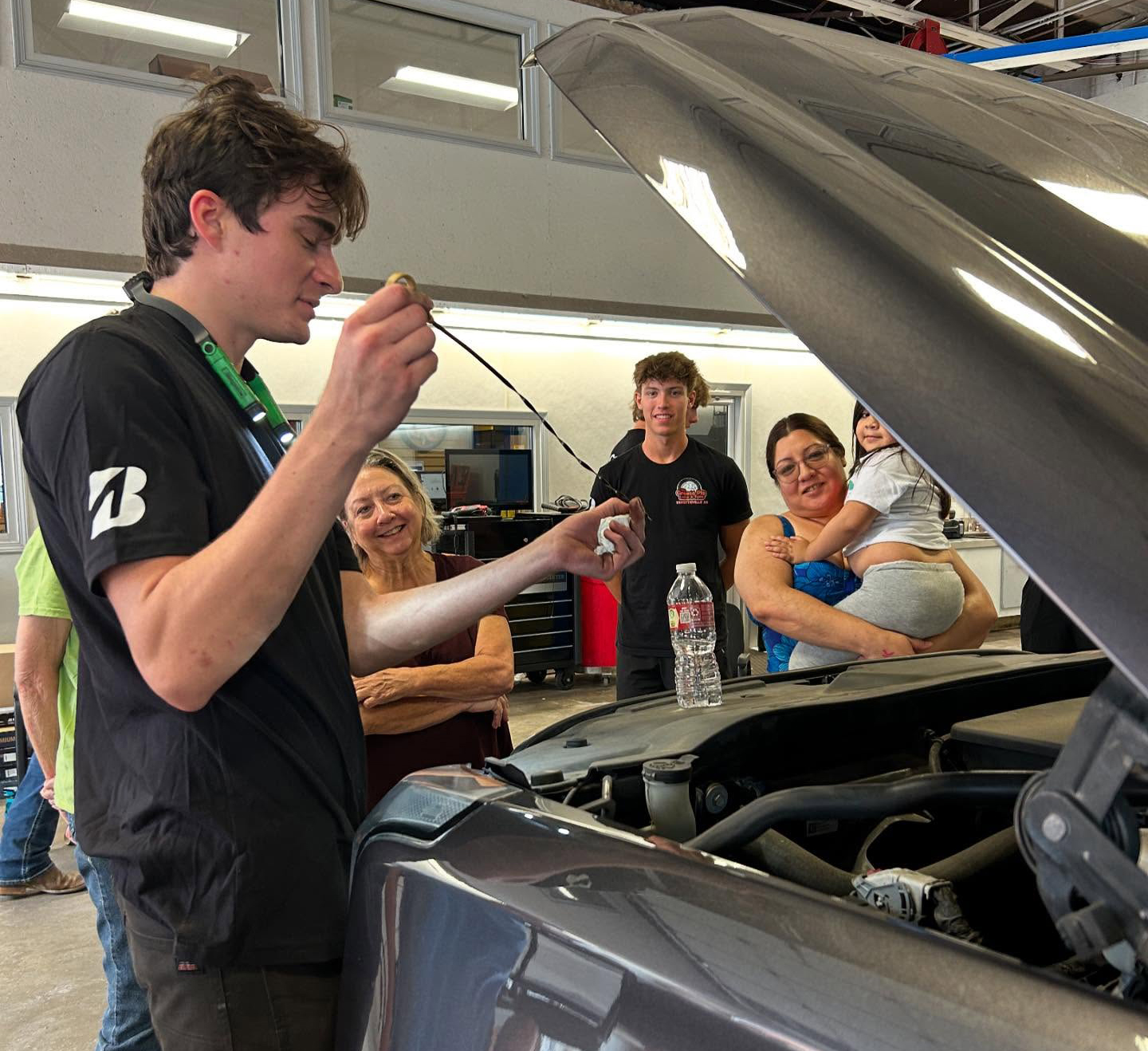 A man checks the oil in a family car