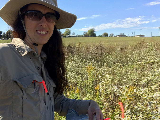 Graduate student standing in a field of Arkansas wildflowers