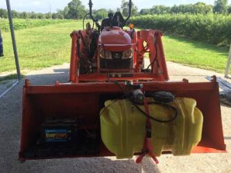 25 gallon sprayer inside the front end loader of a small bulldozer