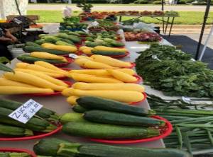 Tables full of vegetables on display for sale at a farmers market