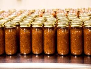 Rows of mason jars filled with processed tomato sauce