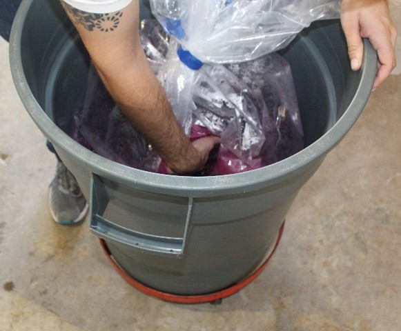 Cap of the red wine must being pushed down by hand during fermentation
