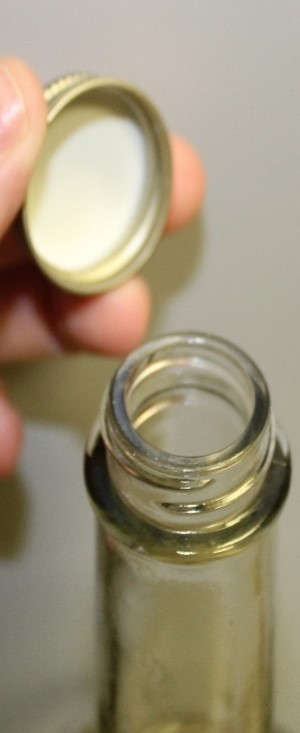 Closeup of a screw cap and a wine bottle