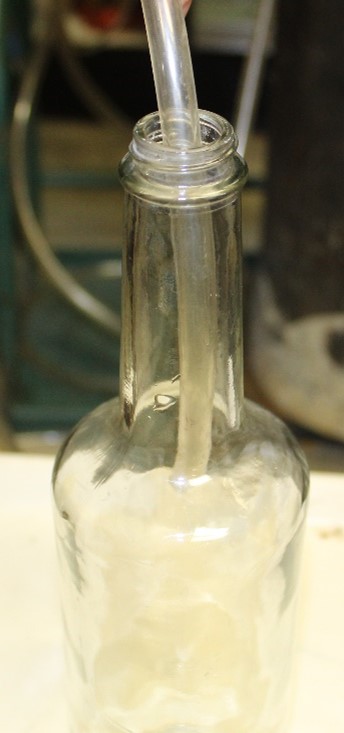 Closeup of a tube inside of a wine bottle being filled with nitrogen gas