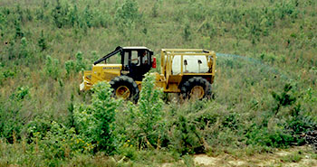 tractor spraying herbicide in a pasture
